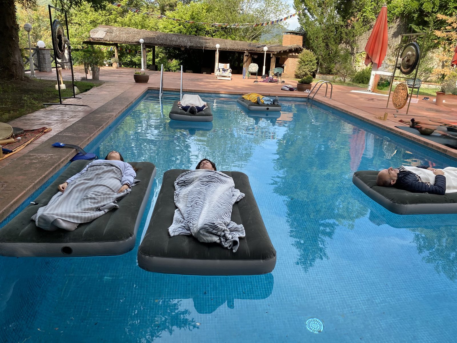 Sound bath session in outdoor pool with gongs