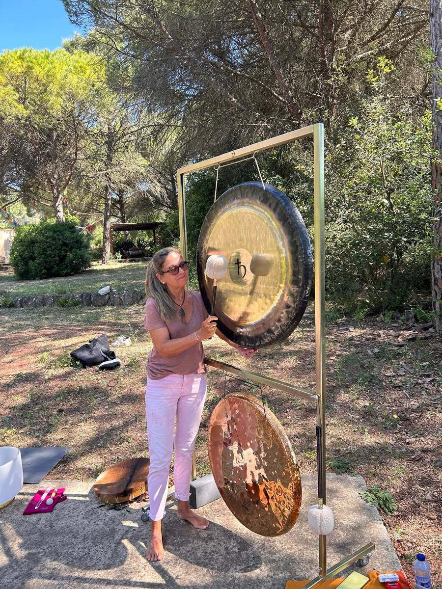 Montse with golden planetary gong outdoors