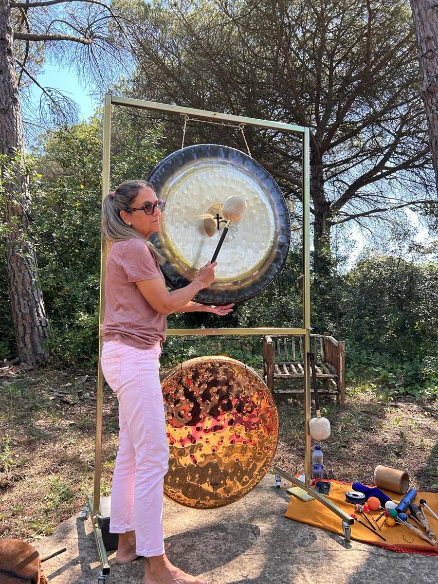 Montse playing the gong in the forest