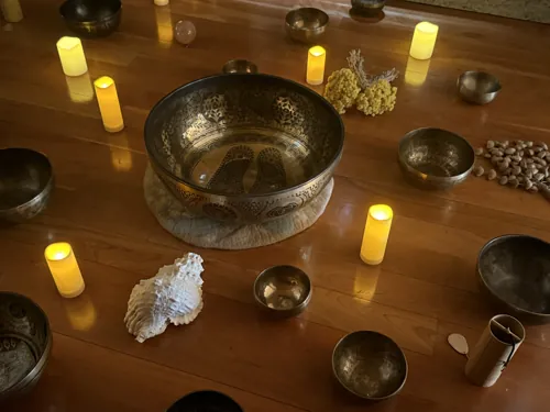 Tibetan singing bowls and engraved bowl with candles at a sound bath