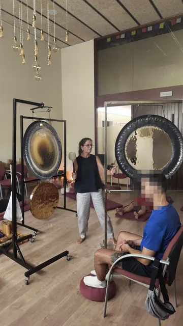 Gong session in the studio with warm light, planetary gongs and participants